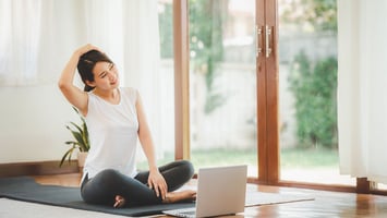 a woman sat doing gentle somatic exercises