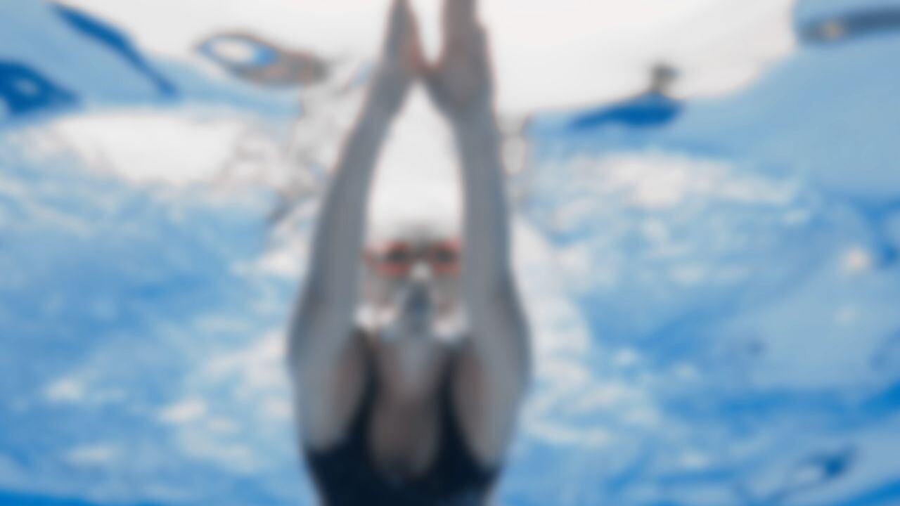 a woman swimming in a pool, blurred